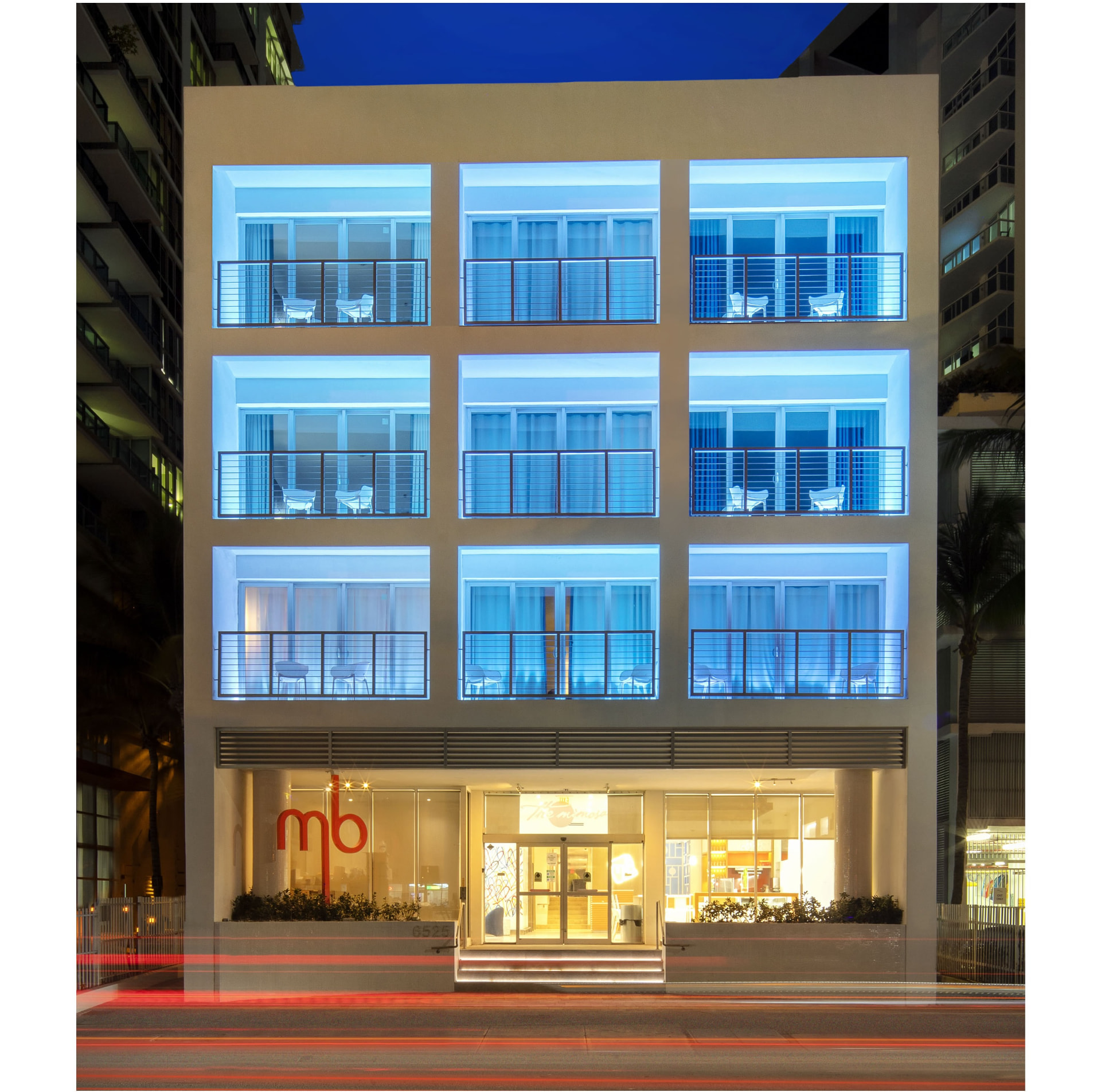 Building facade at night, balconies lit above the street-level entrance