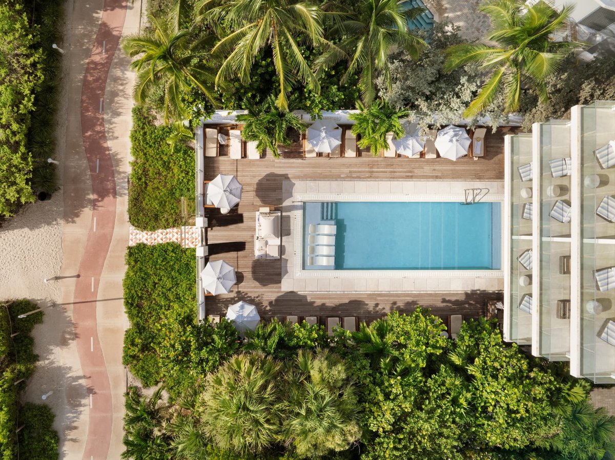 Top-down aerial of the MB Hotel pool terrace, loungers lining the teak deck around a turquoise pool