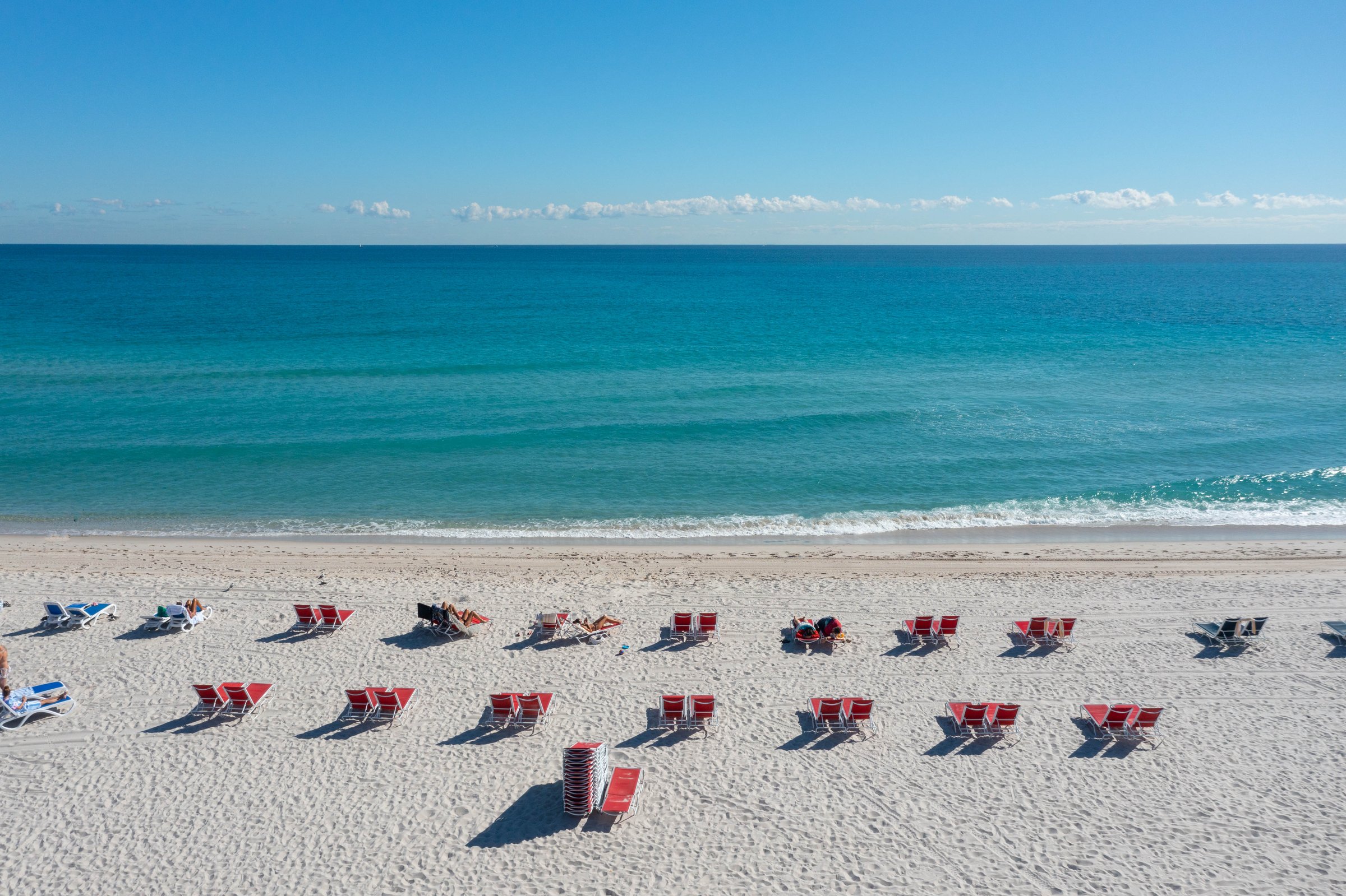 Loungers and umbrellas set out on the sand in front of MB Hotel