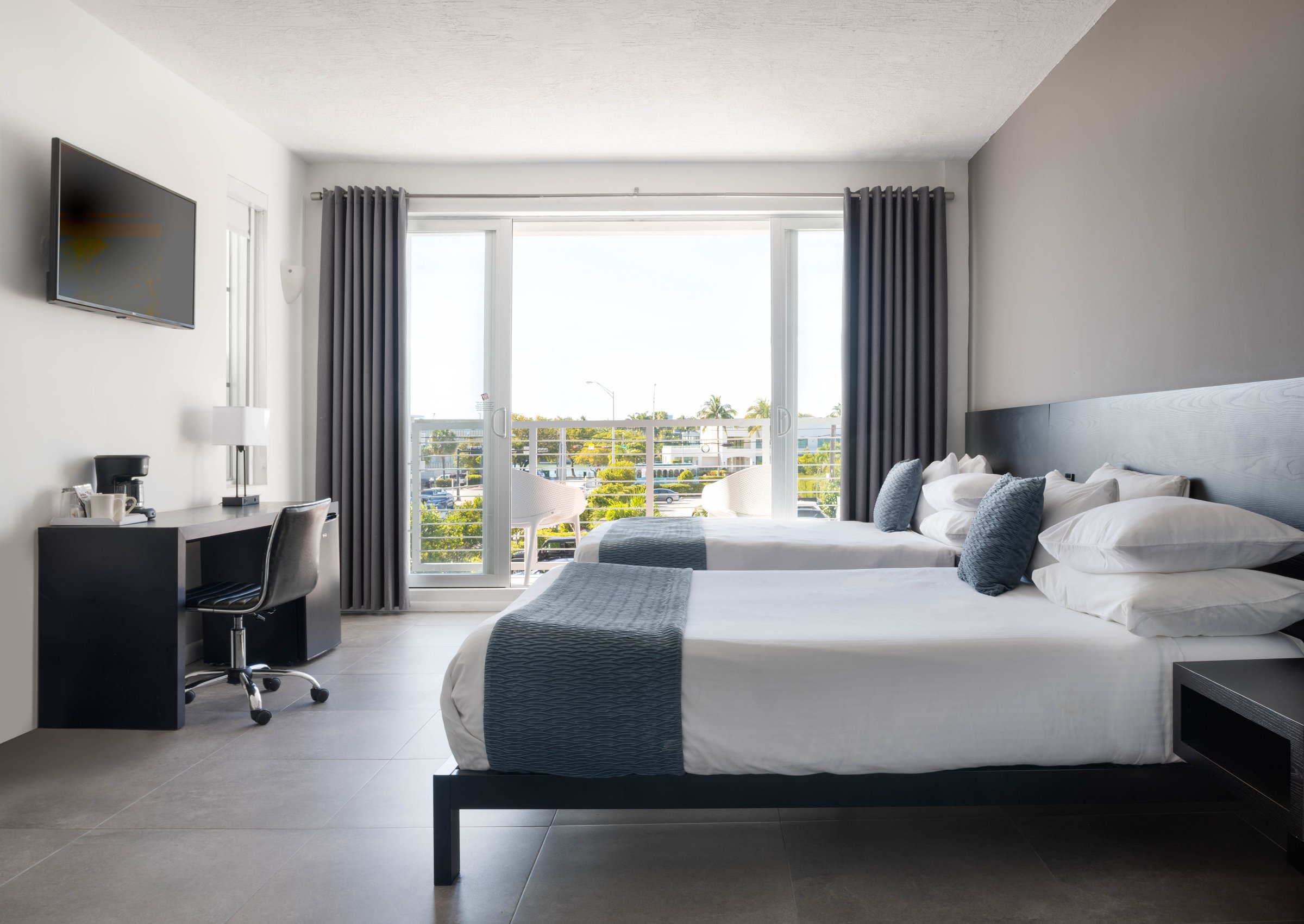 NQQ4 Deluxe Double Queen with two queen beds and a private balcony