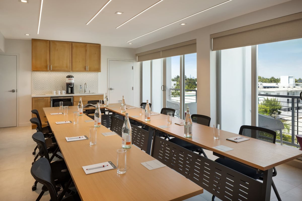MB Hotel's second meeting room, a smaller boardroom with a kitchenette and coffee station at one end and sliding doors to a balcony over the palms and the mid-Beach rooftops