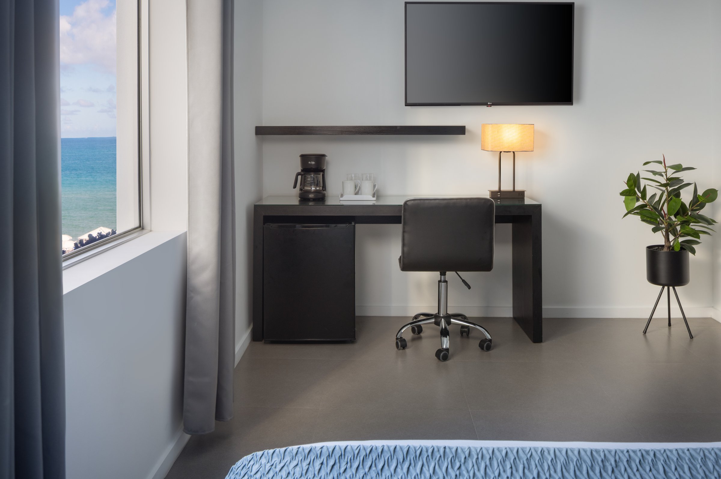 RM1 desk with coffee maker and a partial ocean view through the window